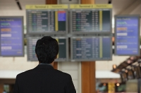 Man reading departure table at airport - Asia Images Group