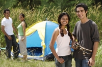 Young friends camping in the wilderness, smiling at camera - Asia Images Group