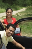 Young couple with car smiling at camera - Asia Images Group
