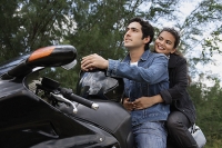 Young couple riding motorbike - Asia Images Group