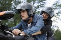 Young couple riding motorbike - Asia Images Group