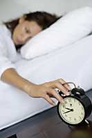 woman being woken up by alarm clock - Alex Mares-Manton