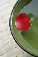 Red petal floating in green bowl - Nugene Chiang