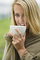 Smiling blond woman, holding big mug at lips - Alex Mares-Manton