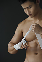 muscular man wrapping hand - Alex Mares-Manton