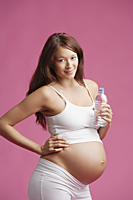 Pregnant woman standing, bottle of water in hand - Alex Mares-Manton