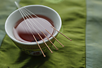 acupuncture needles, bowl of tea - Ellery Chua