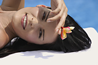 woman lying by pool, hand blocking sun - Alex Mares-Manton