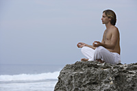 man practicing yoga on rocks - Alex Mares-Manton