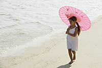 little girl walking on beach under pink umbrella - Alex Mares-Manton