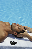 man lying by pool , receiving massage - Alex Mares-Manton