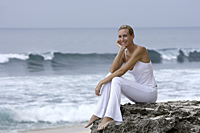 woman sitting on rocks watching ocean - Alex Mares-Manton