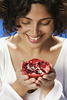 Woman looking at half pomegranate - Alex Mares-Manton