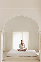 woman meditating in white room - Alex Mares-Manton