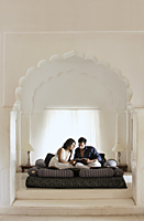 Couple in white room, reading on bed - Alex Mares-Manton