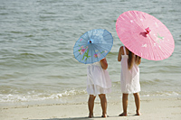 two little girls watching ocean, umbrellas - Alex Mares-Manton