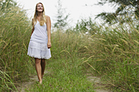 Blond woman walking on grassy path - Alex Mares-Manton