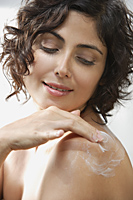 Woman applying lotion to back - Alex Mares-Manton