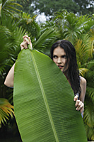 woman standing behind huge tropical leaf - Alex Mares-Manton