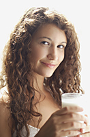 Woman holding glass of milk, smiling - Alex Mares-Manton