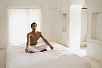 man meditating in white room - Alex Mares-Manton