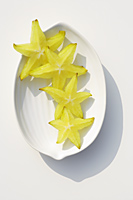 Sliced star fruit on white plate - Alex Mares-Manton