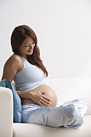 Profile of pregnant woman, smiling at stomach - Alex Mares-Manton