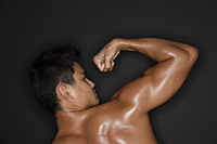 muscular man flexing arm - Alex Mares-Manton