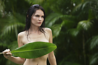 naked woman holding tropical leaf over breasts - Alex Mares-Manton