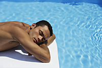 man lying by pool - Alex Mares-Manton