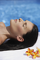 Woman lying by pool, eyes close - Alex Mares-Manton