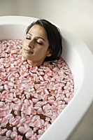 woman in tub with floating petals - Alex Mares-Manton