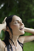 woman in tropical rain shower, hands on head - Alex Mares-Manton