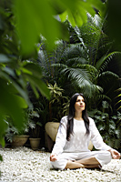 woman practicing yoga surrounded by plants - Alex Mares-Manton