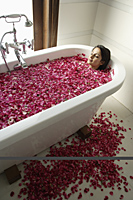 woman in tub with floating petals - Alex Mares-Manton