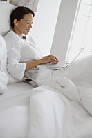 Woman in bed on laptop - Alex Mares-Manton