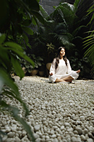 woman practicing yoga surrounded by plants - Alex Mares-Manton