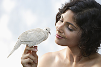 Woman holding dove on finger - Alex Mares-Manton