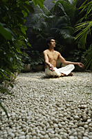 man practicing yoga surrounded by plants - Alex Mares-Manton
