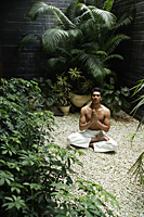 man practicing yoga surrounded by plants - Alex Mares-Manton