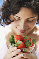 woman smelling bowl of strawberries - Alex Mares-Manton