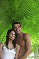 couple under giant leaf in rain shower - Alex Mares-Manton