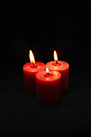 Three lit red candles - Nugene Chiang