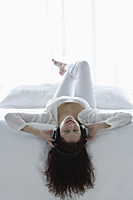 Woman lying on back with headphones one - Alex Mares-Manton
