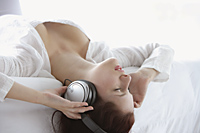 Profile of woman lying back with headphones on - Alex Mares-Manton