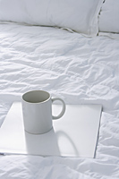 Bed with coffee cup on tray - Alex Mares-Manton