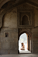 Woman sitting in doorway of ancient monument - Alex Mares-Manton