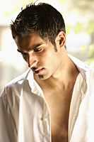 Profile of man with unbuttoned white shirt on - Alex Mares-Manton