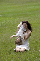 Mother and daughter tickling on grass - Alex Mares-Manton