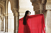 Woman in red shawl, standing in ancient monument - Alex Mares-Manton